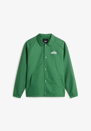 Grüne leichte Jacke mit Druckknöpfen, Seitentaschen und einem Kragen. Auf der linken Brust befindet sich das "Vans Off the Wall"-Logo. Glatte Textur.