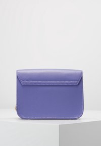 Bolso de mano púrpura con textura, cierre con solapa, bordes lisos y detalles de costura sutiles. Diseño compacto adecuado para uso casual.