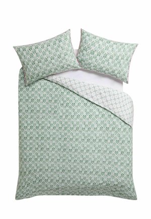 Letto matrimoniale con copripiumino a motivo geometrico verde e bianco e federe abbinate, un angolo ripiegato per mostrare il motivo rovesciato.