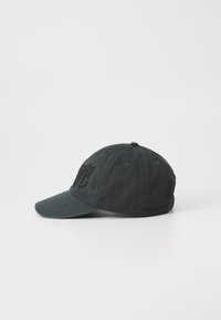 Schwarze Baseballkappe mit gebogenem Schirm, aus Stoff gefertigt, mit einem gestickten Design auf der Vorderseite und Belüftungslöchern an den Seiten.