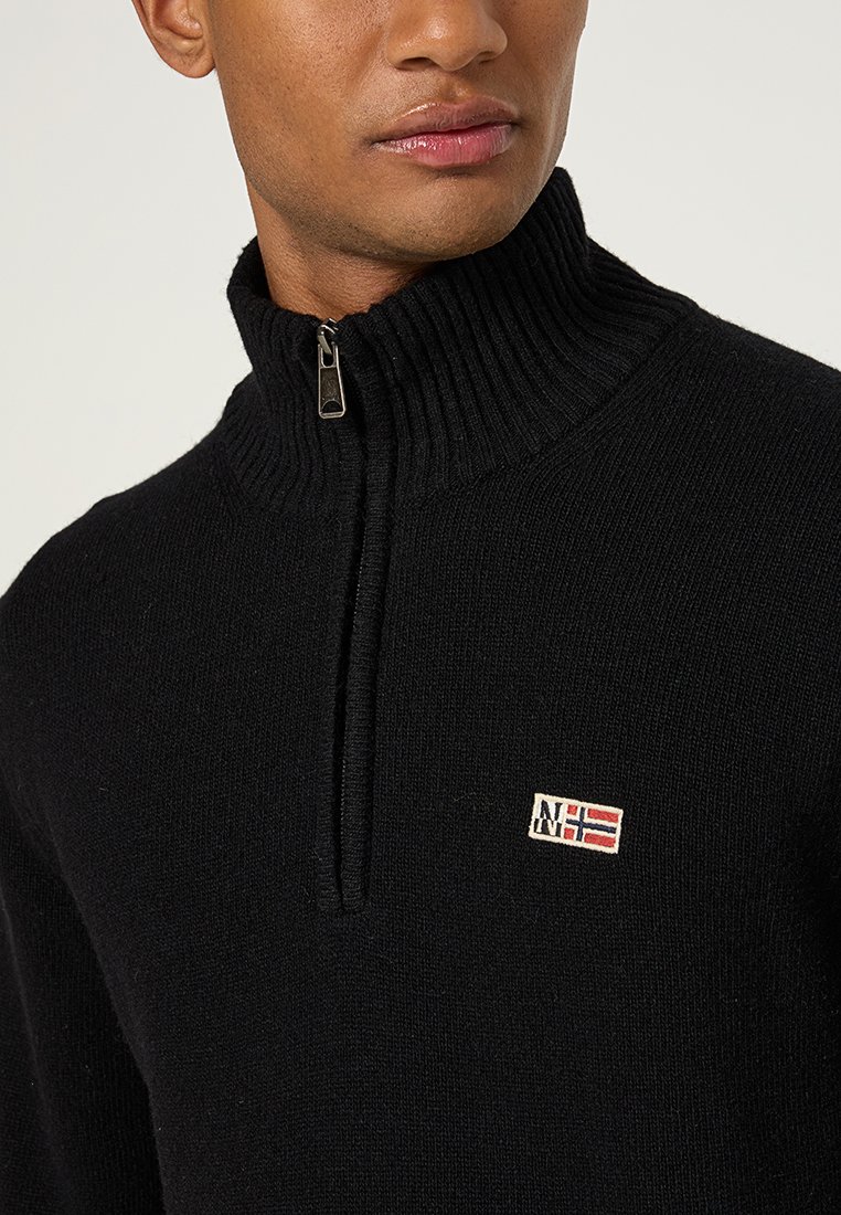 Schwarzer Reißverschluss-Pullover mit geripptem Kragen, ausgestattet mit einem kleinen gestickten Logo. Der Stoff ist gestrickt und zeigt eine glatte Textur. Minimalistisches Design.