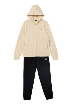 Felpa beige con cappuccio e zip integrale con tasche abbinata a pantaloni della tuta neri, entrambi con i loghi EA7 Emporio Armani.