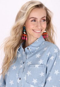 Világoskék farmering fehér csillagmintával, gombos elülső résszel, gallérral és egy zsebből álló kialakítással. Színes, lógós fülbevalók is találhatóak rajta.