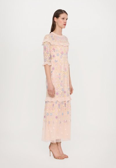 Roze bloemengebrodeerde jurk met een transparante overlay, ruches op de mouwen en een gelaagde zoom. Kenmerken zijn pastelbloemen en een vloeiende silhouet.