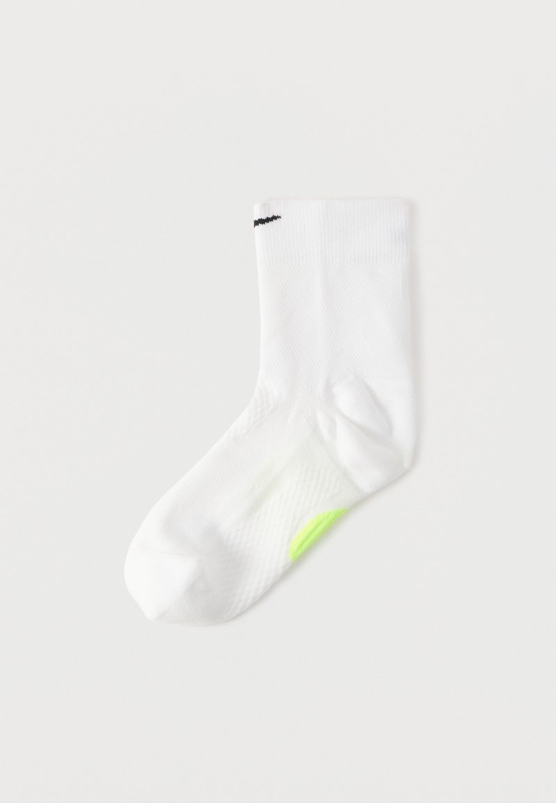 Λευκή αθλητική κάλτσα με υφασμάτινη υφή, που διαθέτει μαύρο λογότυπο στο πάνω μέρος και πράσινη λεπτομέρεια στο πλάι κοντά στη φτέρνα.