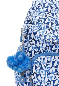 Blue patterned backpack with geometric shapes, featuring a textured blue furry gorilla keychain and silver hardware accents.