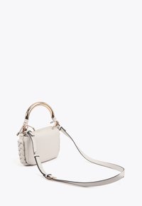 Malá šedá kožená kabelka se zlatým zaobleným úchytem, pletenou texturou na jedné straně a nastavitelným popruhem. Minimalistický design s elegantními liniemi.