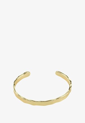 Zlatna narukvica s manžetnom s teksturiranim, valovitim dizajnom. Ovalni krajevi nježno se sužavaju, ističući glatku, poliranu površinu i minimalistički stil.