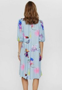 Lichtblauwe jurk met een bloemenprint, voorzien van puffmouwen, knielange snit, zacht materiaal en levendig gekleurde bloemen in verschillende stijlen.