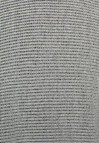 Tessuto texturizzato in tonalità di grigio e bianco, con un motivo ripetuto di linee curve e piccoli punti.