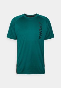 Tyrkysové tričko s krátkým rukávem s černými bočními detaily. Na levé straně je vertikálně umístěno černé logo Puma a má kulatý výstřih.