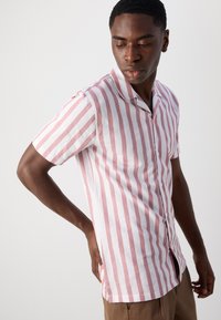 Maglietta a maniche corte con righe orizzontali rosa e bianche, colletto button-down e tessuto morbido con una vestibilità comoda.