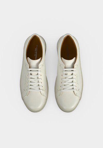 Ζευγάρι λευκά δερμάτινα sneakers χαμηλού τύπου με λευκά κορδόνια, από πάνω σε λευκό φόντο.