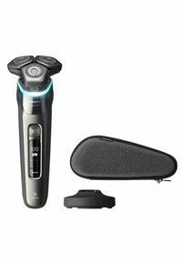 Philips Series 9000 elektrische scheerapparaat, slank zwart met zilveren accenten, drie ronde koppen, LED-display, met een grijze reistas en oplaadstation.