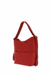 Sac à épaule en tissu rouge avec une surface texturée, un grand compartiment principal, une sangle réglable et une poche zippée à l'avant.