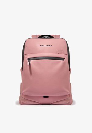 Sac à dos rose avec une finition lisse et mate, comprenant une poche avant zippée, des bretelles rembourrées et un logo en haut. Design compact et épuré.