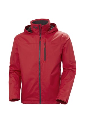 Chaqueta impermeable roja con un alto cuello, frontal con cremallera y capucha ajustable. Presenta detalles de cremallera negra y un pequeño logo en el pecho.