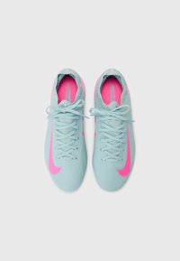 Baskets de sport bleu clair avec une surface texturée, dotées d'un swoosh Nike rose, d'un design à lacets et de semelles intérieures roses.