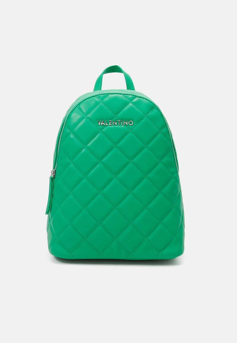 Sac à dos matelassé vert de forme arrondie, doté de ferrures argentées et d'une poche zippée sur le côté. Le nom de la marque est embossé à l'avant.