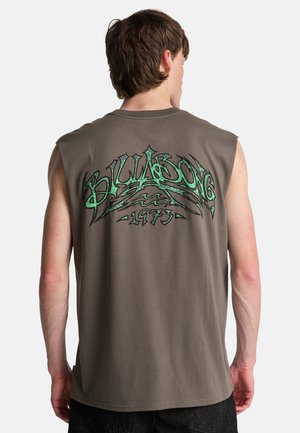 Maglietta grigia senza maniche in cotone con una grande stampa grafica verde e nera sul retro, che mostra "Billabong 1973" ed elementi di design ondulati.