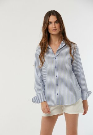 Chemise légère à boutons, rayée bleu et blanc. Caractéristiques : un col, des manches longues et un ourlet arrondi. Tissu en coton.