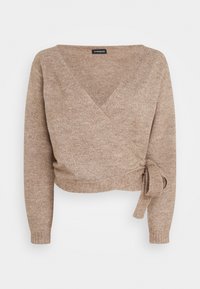 Maglione avvolto beige accorciato realizzato in materiale morbido, con scollatura a V profonda, maniche lunghe e dettaglio con nodo sul lato.