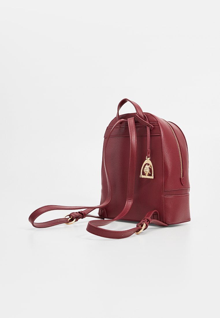 Zaino rosso in pelle con finitura testurizzata, due spallacci regolabili, maniglia superiore, dettagli in oro e tasca anteriore con zip.