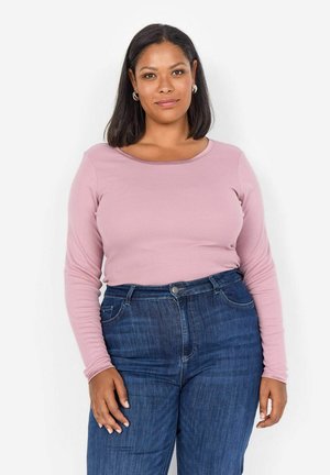 Light pink long-sleeve top with a rounded neckline, paired with high-waisted dark blue jeans featuring front pockets and a button closure.