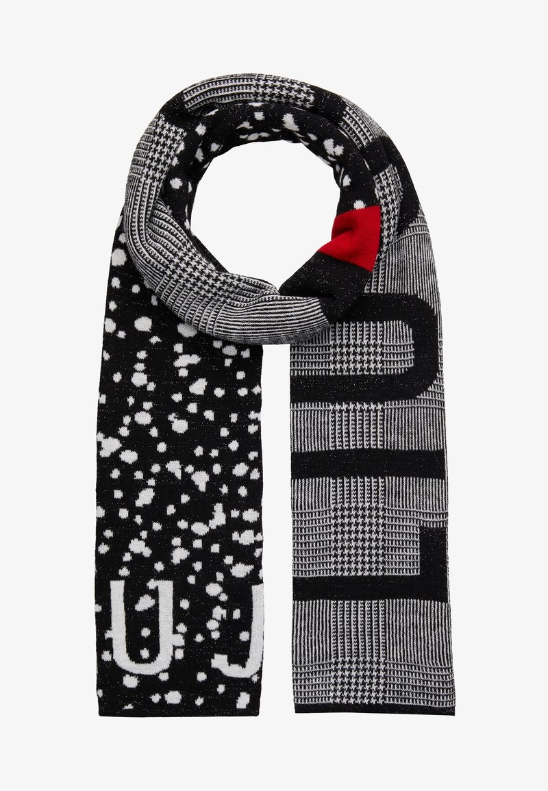 Écharpe à motifs noir et blanc avec des blocs et des motifs pied-de-poule, des taches blanches éparpillées, et un petit patch rouge près du sommet.