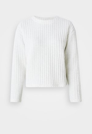 Weißes Langarmoberteil mit Rippstruktur und Rundhalsausschnitt. Das cropped Design hat einen flachen Saum und dezente Nähdetails.