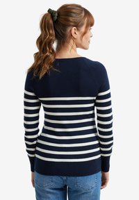 Navy und creme gestreifter Pullover mit langen Ärmeln und Rundhalsausschnitt, aus weichem Material gefertigt, mit einer taillierten Silhouette und gerippten Bündchen.