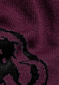 Tessuto lavorato a maglia di un profondo bordeaux con una trama testurizzata. Presenta un significativo motivo di design nero, creando un effetto visivo a contrasto.