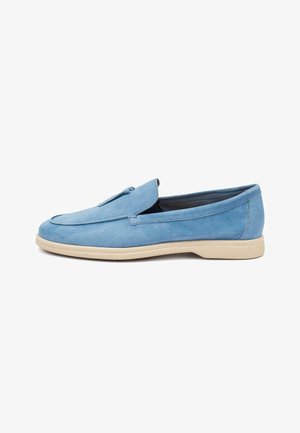 Mocassin pour homme en daim bleu avec semelle beige et détail de pampilles sur le dessus, présenté de côté sur un fond blanc.