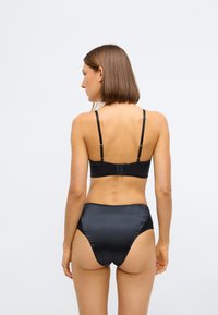 Zwart lingerie set met een gladde, satijnen afwerking, verstelbare bandjes, haaksluiting en een hoge taille onderkant.
