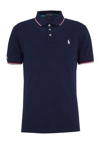 Tmavě modré polo tričko z bavlny, s tříknoflíkovým zapínáním, bílým vyšitým logem a límečkem a manžetami s červenobílými pruhy.