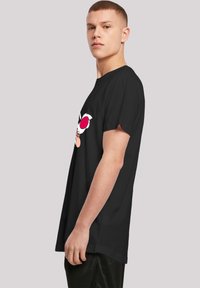 Black cotton t-shirt featuring a cartoon design with white and pink accents, loose fit, round neckline, and short sleeves.