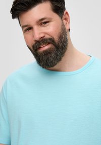 Lichtblauwe T-shirt met korte mouwen, gemaakt van zachte stof, met een ronde halslijn en subtiele textuur, tentoongesteld op een neutrale achtergrond.