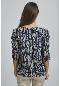 Blusa navy con motivo astratto beige e azzurro chiaro, dotata di maniche a tre quarti arricciate e scollatura rotonda.