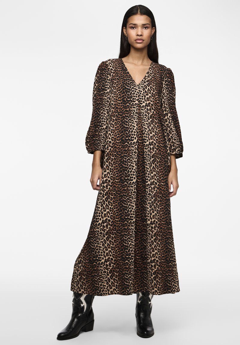 Abito maxi con stampa leopardo, maniche lunghe e puffate, e scollatura a V, realizzato in tessuto morbido. Abbinato a stivaletti neri alla caviglia.