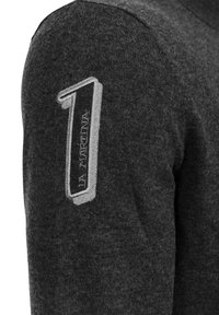 Mörkgrå ulltröja med ett framträdande grått broderat nummer "1" på vänster axel och varumärket "La Martina" under.