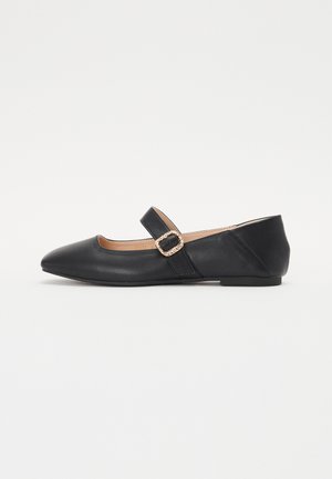 Chaussures plates en cuir noir avec un bout pointu, dotées d'une lanière à boucle. Design élégant, texture lisse et semelle à profil bas.