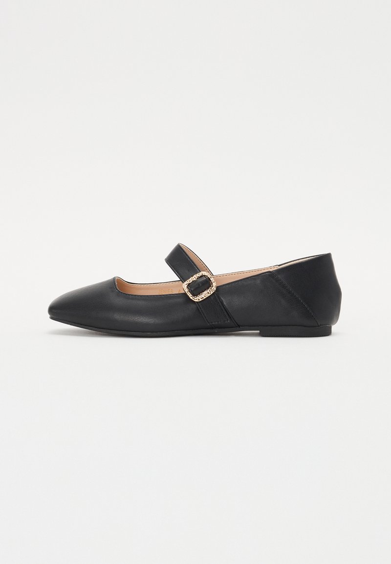 Chaussures plates en cuir noir avec un bout pointu, dotées d'une lanière à boucle. Design élégant, texture lisse et semelle à profil bas.