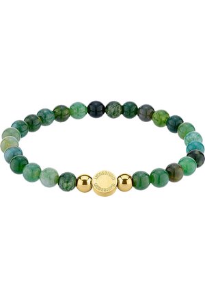 Grünsteinarmband mit unterschiedlichen Grüntönen, durchsetzt mit glänzenden schwarzen und goldenen Akzentperlen, darunter eine geprägte goldene Scheibe.