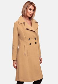 Beige dubbele-breasted wollen jas met een brede kraag, verticale naaddetails en zwarte knopen, met een getailleerde pasvorm en zijzakken.