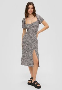Robe midi à imprimé floral avec un décolleté carré, des manches bouffantes et une fente sur le côté. Fabriquée en tissu léger, dans des teintes de noir et rose.