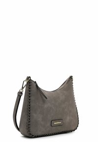 Gray suede handbag with stitched detailing, zipper closure, adjustable strap, and a gold-tone logo plate on the front. Slim, curved shape.