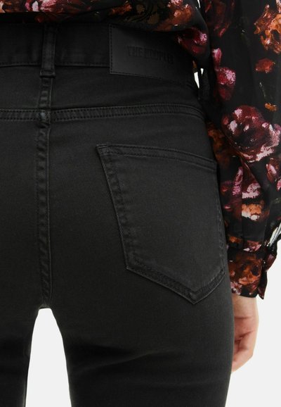 Vaqueros de mezclilla negra con una textura suave y un corte clásico. Presenta un bolsillo trasero y una etiqueta de cuero con la marca en la cinturilla.
