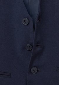 Marineblaues Weste aus strukturiertem Stoff, mit vier schwarzen Knöpfen, einem V-Ausschnitt und zwei schmalen Taschen auf der Vorderseite.