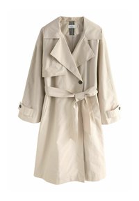 Beige trenchcoat med bred krave, knaplukning og et bundet bælte i taljen. Har lange ærmer med knappede manchetter. Glat stofstruktur.