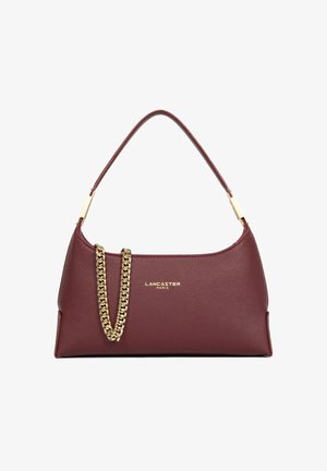 Donkerrode leren Lancaster Paris handtas met enkele handgreep en goudkleurige kettinkdetail aan de voorkant tegen een witte achtergrond.